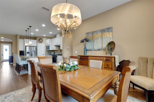 802 Soria Ln, Davenport, FL 33837 - dining space featuring a chandelier, light wood-style floors, recessed lighting, and arched walkways