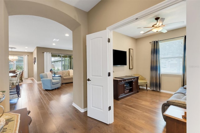 802 Soria Ln, Davenport, FL 33837 - living area featuring arched walkways, light wood-style floors, a chandelier, and a ceiling fan