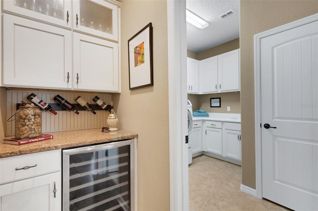 802 Soria Ln, Davenport, FL 33837 - indoor dry bar featuring wine cooler, light tile patterned flooring, tasteful backsplash, and washer / clothes dryer