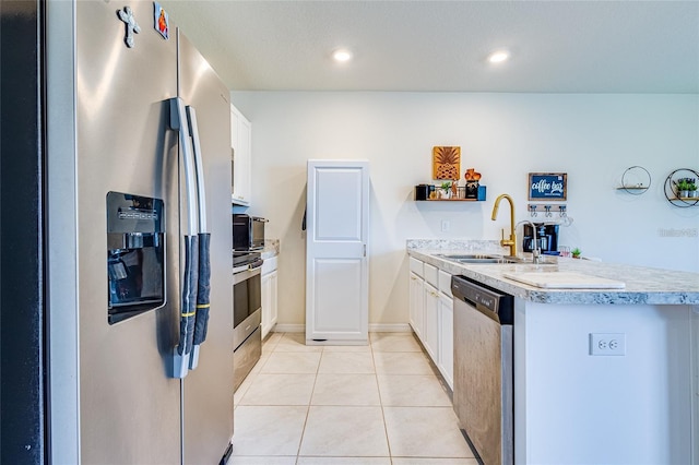 320 Boardwalk Ave, Haines City, FL 33844 - kitchen with stainless steel appliances, a peninsula, white cabinets, light countertops, and light tile patterned flooring