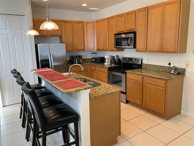 352 Cherokee Ave, Haines City, FL 33844 - kitchen with stainless steel appliances, light tile patterned flooring, a kitchen bar, hanging light fixtures, and stone countertops