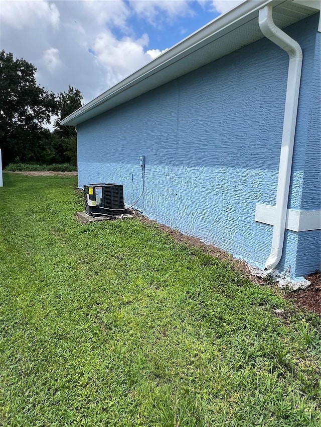 2211 Julianna Ct, Saint Cloud, FL 34769 - view of side of property with a central AC unit and a yard