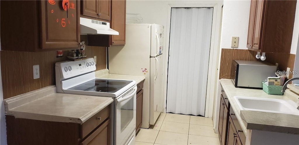 2002 Cascades Blvd Unit 202, Kissimmee, FL 34741 - kitchen featuring under cabinet range hood, white electric stove, and light tile patterned floors