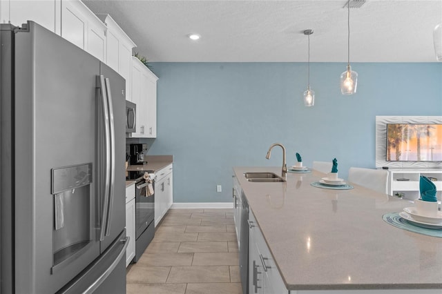 4840 Romeo Cir, Kissimmee, FL 34746 - kitchen featuring appliances with stainless steel finishes, a kitchen island with sink, white cabinetry, pendant lighting, and a textured ceiling