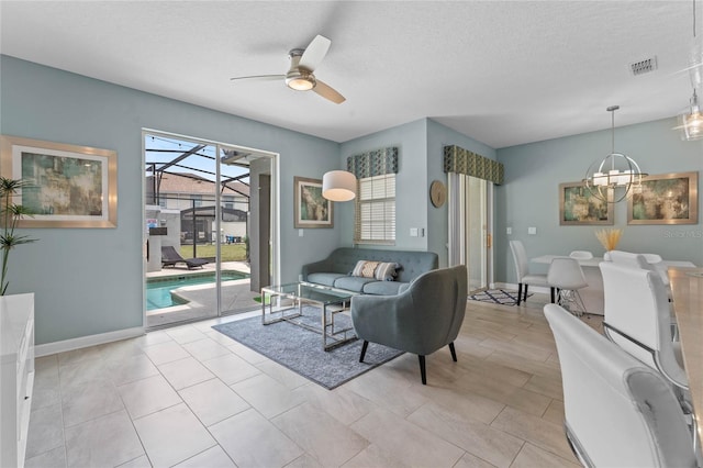 4840 Romeo Cir, Kissimmee, FL 34746 - living room featuring a ceiling fan, a chandelier, a sunroom, and a textured ceiling