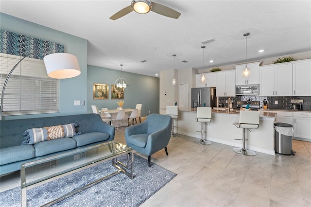 4840 Romeo Cir, Kissimmee, FL 34746 - living room featuring a ceiling fan and a chandelier