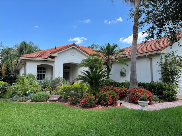 99 Auburn Dr, Kissimmee, FL 34759 - mediterranean / spanish home featuring a tiled roof, stucco siding, and a front yard