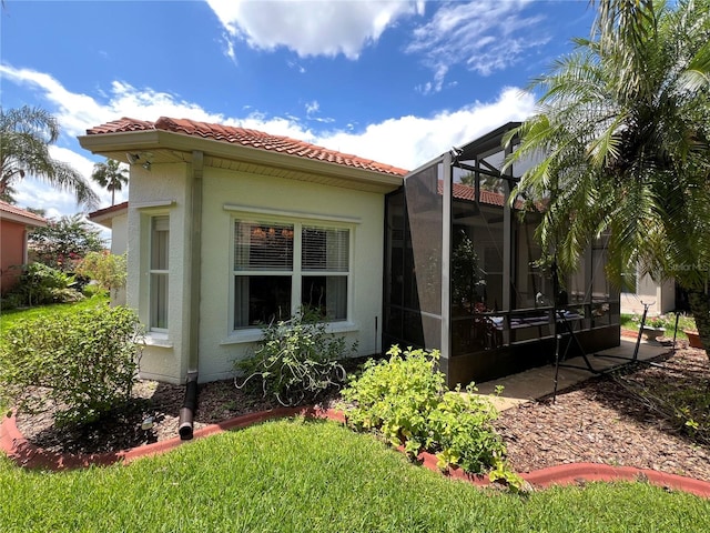 99 Auburn Dr, Kissimmee, FL 34759 - view of side of home featuring stucco siding, a tile roof, and a lanai