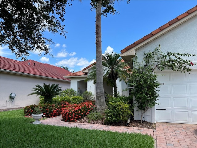99 Auburn Dr, Kissimmee, FL 34759 - view of side of property with a tile roof, stucco siding, and a garage