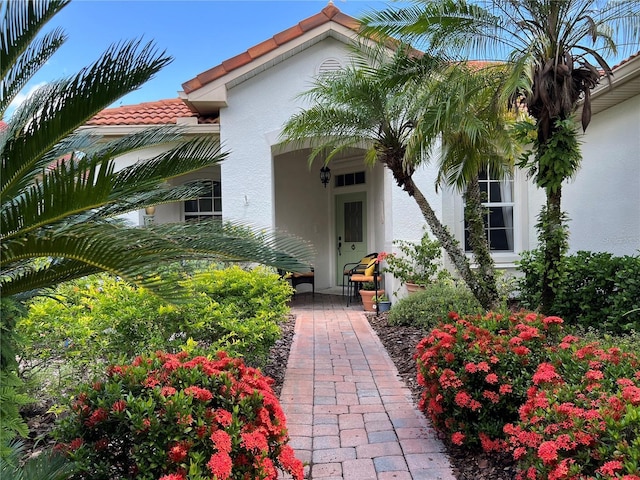 99 Auburn Dr, Kissimmee, FL 34759 - property entrance with stucco siding and a tiled roof
