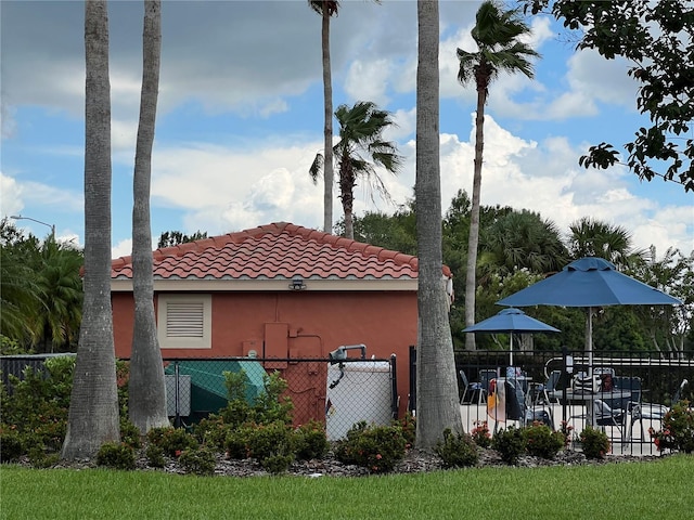 99 Auburn Dr, Kissimmee, FL 34759 - view of side of property with a tiled roof and stucco siding