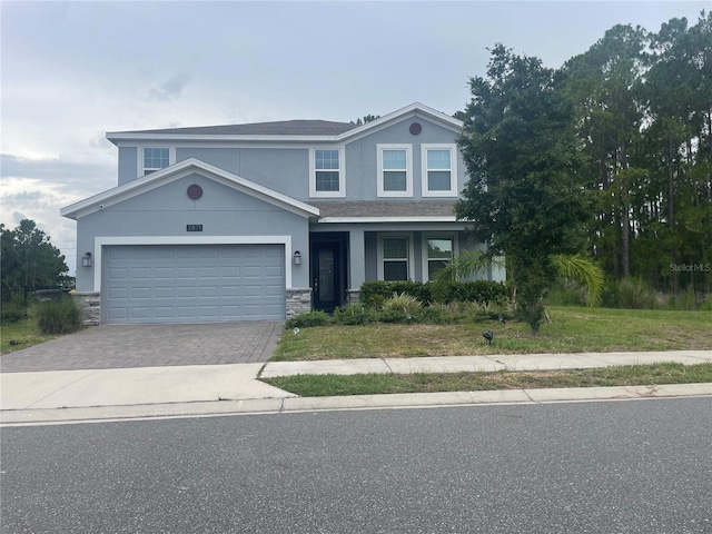2871 Camden Way, Davenport, FL 33837 - view of front of home featuring driveway, stucco siding, stone siding, a garage, and a shingled roof