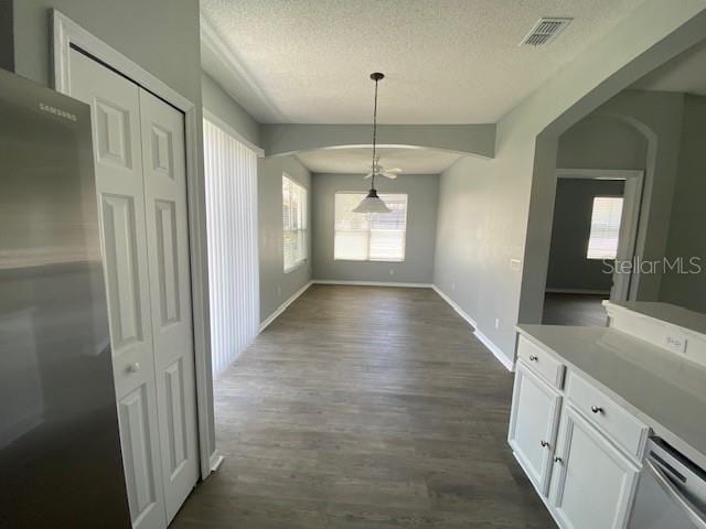9048 Saint Andrews Way, Mount Dora, FL 32757 - unfurnished dining area featuring a textured ceiling and dark wood finished floors