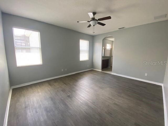 9048 Saint Andrews Way, Mount Dora, FL 32757 - spare room featuring arched walkways, a ceiling fan, and dark wood finished floors