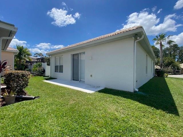 9048 Saint Andrews Way, Mount Dora, FL 32757 - rear view of house with stucco siding and a yard