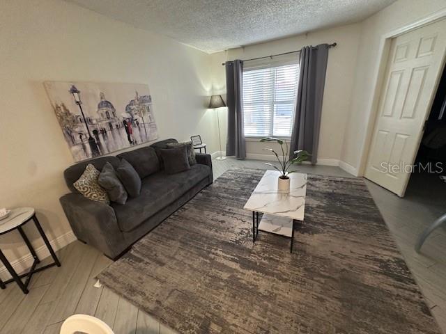 3100 Parkway Blvd Unit 316, Kissimmee, FL 34747 - living area featuring a textured ceiling and wood finished floors
