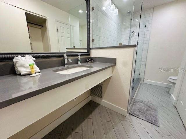 3100 Parkway Blvd Unit 316, Kissimmee, FL 34747 - bathroom featuring a shower stall, vanity, wood tiled floors, and recessed lighting