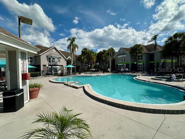 3100 Parkway Blvd Unit 316, Kissimmee, FL 34747 - community pool featuring a patio area, a residential view, and a jacuzzi