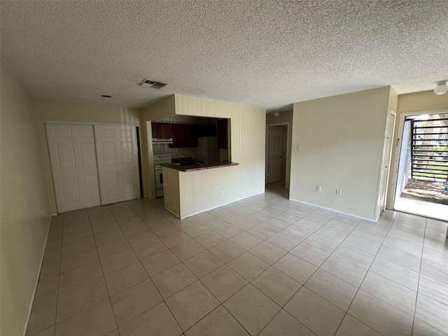 3828 Bowline Cir Unit 101, Kissimmee, FL 34741 - unfurnished living room featuring light tile patterned floors and a textured ceiling