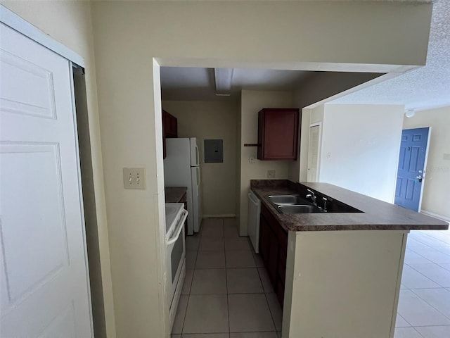 3828 Bowline Cir Unit 101, Kissimmee, FL 34741 - kitchen with white appliances, dark countertops, light tile patterned flooring, and a peninsula