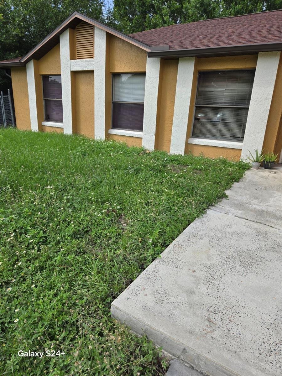 621 N Delmonte Ct, Kissimmee, FL 34758 - exterior view of stucco siding, a downspout, and a shingled roof