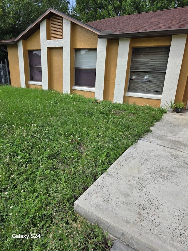 621 N Delmonte Ct, Kissimmee, FL 34758 - exterior view of stucco siding, a downspout, and a shingled roof