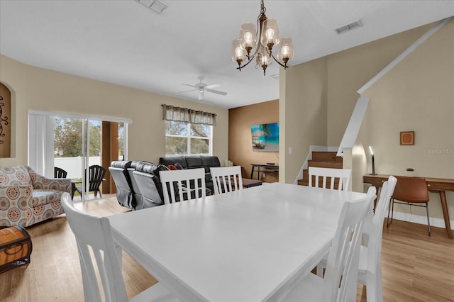 2234 Calabria Ave, Davenport, FL 33897 - dining room featuring light wood-type flooring, a chandelier, a ceiling fan, and stairway