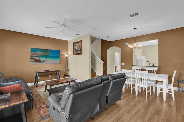 2234 Calabria Ave, Davenport, FL 33897 - living room with arched walkways, ceiling fan, light wood-style floors, stairway, and a chandelier