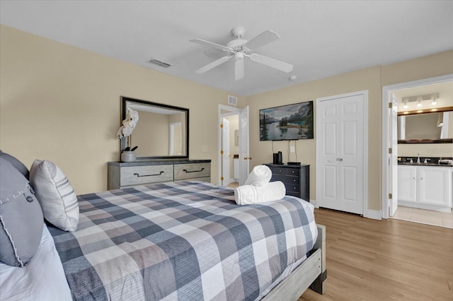2234 Calabria Ave, Davenport, FL 33897 - bedroom with light wood finished floors, a ceiling fan, and ensuite bath
