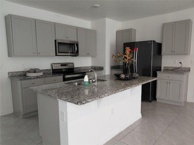 2132 Desert Rose Dr, Davenport, FL 33837 - kitchen with stainless steel appliances, gray cabinetry, light stone counters, and light tile patterned floors