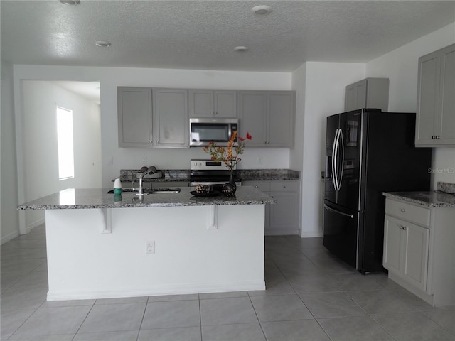 2132 Desert Rose Dr, Davenport, FL 33837 - kitchen featuring stainless steel microwave, black refrigerator with ice dispenser, electric range oven, gray cabinets, and stone countertops