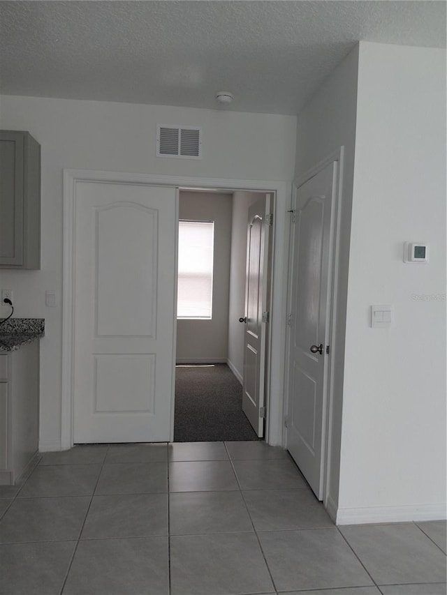 2132 Desert Rose Dr, Davenport, FL 33837 - hall featuring light tile patterned flooring and a textured ceiling