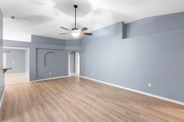 2126 Wekiva Reserve Blvd, Apopka, FL 32703 - unfurnished living room with light wood-style floors, ceiling fan, arched walkways, and vaulted ceiling