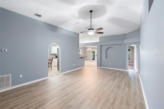 2126 Wekiva Reserve Blvd, Apopka, FL 32703 - unfurnished living room featuring arched walkways, a ceiling fan, a chandelier, and light wood-style floors