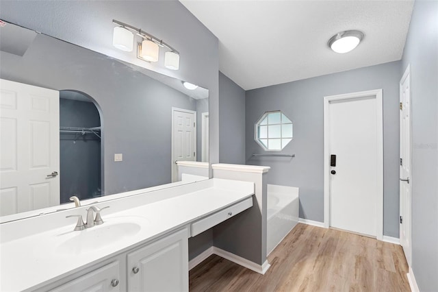 2126 Wekiva Reserve Blvd, Apopka, FL 32703 - bathroom featuring a garden tub, wood finished floors, and vanity