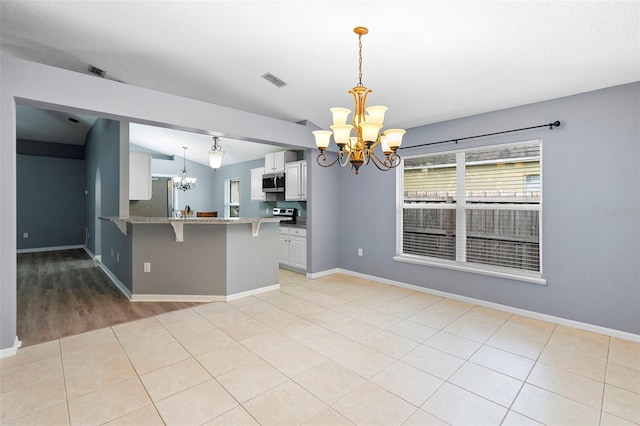 2126 Wekiva Reserve Blvd, Apopka, FL 32703 - kitchen with a chandelier, appliances with stainless steel finishes, white cabinetry, a breakfast bar, and a peninsula