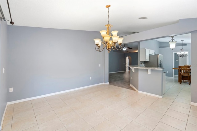 2126 Wekiva Reserve Blvd, Apopka, FL 32703 - kitchen with a chandelier, stainless steel refrigerator with ice dispenser, white cabinetry, and arched walkways