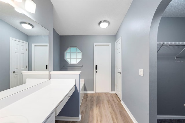 2126 Wekiva Reserve Blvd, Apopka, FL 32703 - full bath featuring vanity, wood finished floors, a garden tub, a textured ceiling, and a walk in closet