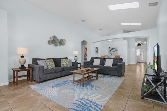242 Saragossa Ave, Davenport, FL 33897 - living room featuring arched walkways, light tile patterned floors, high vaulted ceiling, and a skylight