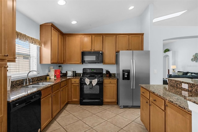 242 Saragossa Ave, Davenport, FL 33897 - kitchen featuring black appliances, vaulted ceiling, arched walkways, dark stone counters, and light tile patterned floors