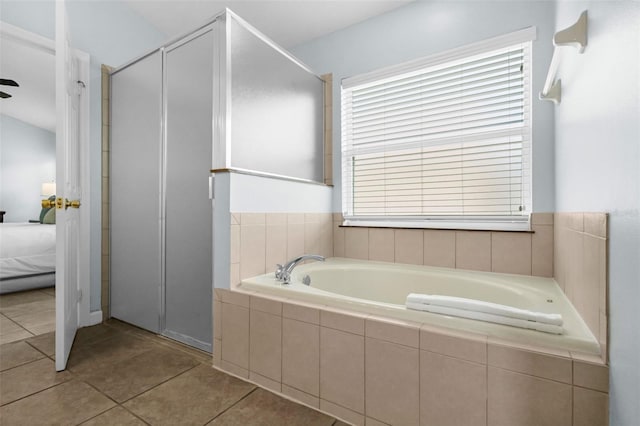 242 Saragossa Ave, Davenport, FL 33897 - ensuite bathroom with a garden tub, tile patterned flooring, and a shower stall