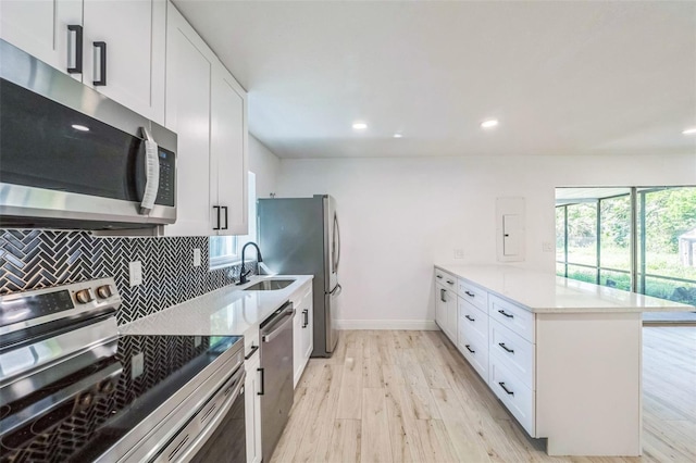4212 Harry Dr, Fruitland Park, FL 34731 - kitchen with appliances with stainless steel finishes, a peninsula, light wood-style flooring, white cabinetry, and recessed lighting
