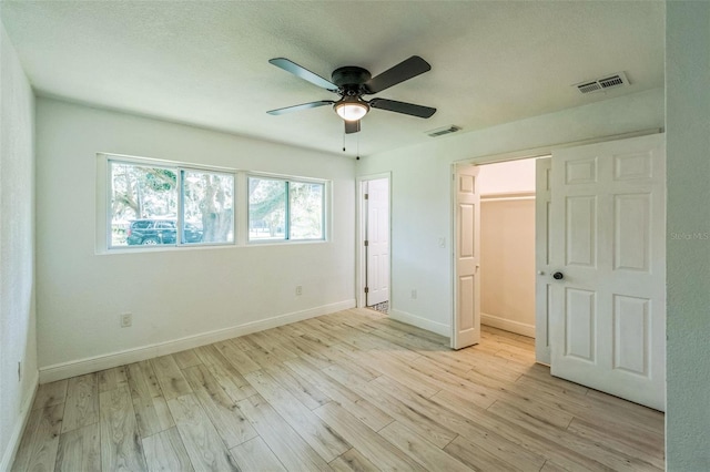 4212 Harry Dr, Fruitland Park, FL 34731 - unfurnished bedroom featuring light wood finished floors, a walk in closet, and ceiling fan