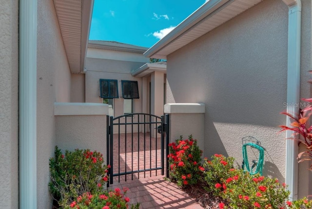 3432 Fallbrook Dr, Poinciana, FL 34759 - view of exterior entry with stucco siding and a gate