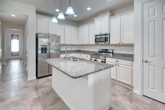 3432 Fallbrook Dr, Poinciana, FL 34759 - kitchen with stainless steel appliances, a center island with sink, light stone counters, white cabinets, and recessed lighting