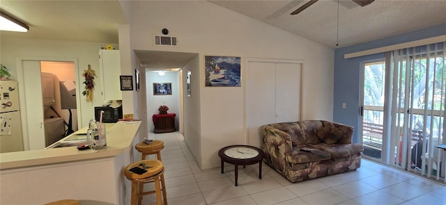 5291 Images Cir Unit 302, Kissimmee, FL 34746 - living room featuring ceiling fan, healthy amount of natural light, light tile patterned flooring, lofted ceiling, and a textured ceiling