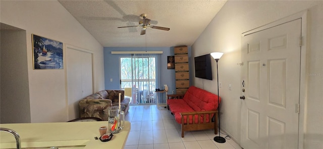 5291 Images Cir Unit 302, Kissimmee, FL 34746 - living area featuring vaulted ceiling, a ceiling fan, light tile patterned flooring, and a textured ceiling