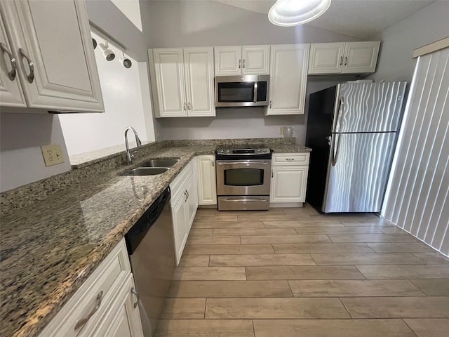 12161 Sandal Creek Way, Orlando, FL 32824 - kitchen with stainless steel appliances, light wood-type flooring, white cabinetry, and stone counters