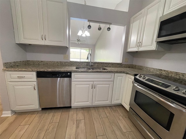 12161 Sandal Creek Way, Orlando, FL 32824 - kitchen with stainless steel appliances, a chandelier, light wood finished floors, and white cabinets