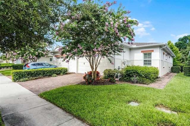 2419 Datura Loop, Saint Cloud, FL 34772 - view of front of home featuring decorative driveway, a front lawn, stucco siding, and a garage